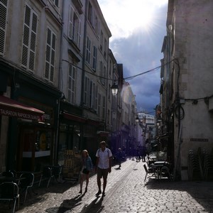 Rue en pavée bordée de maisons avec passants et soleil  - France  - collection de photos clin d'oeil, catégorie rues